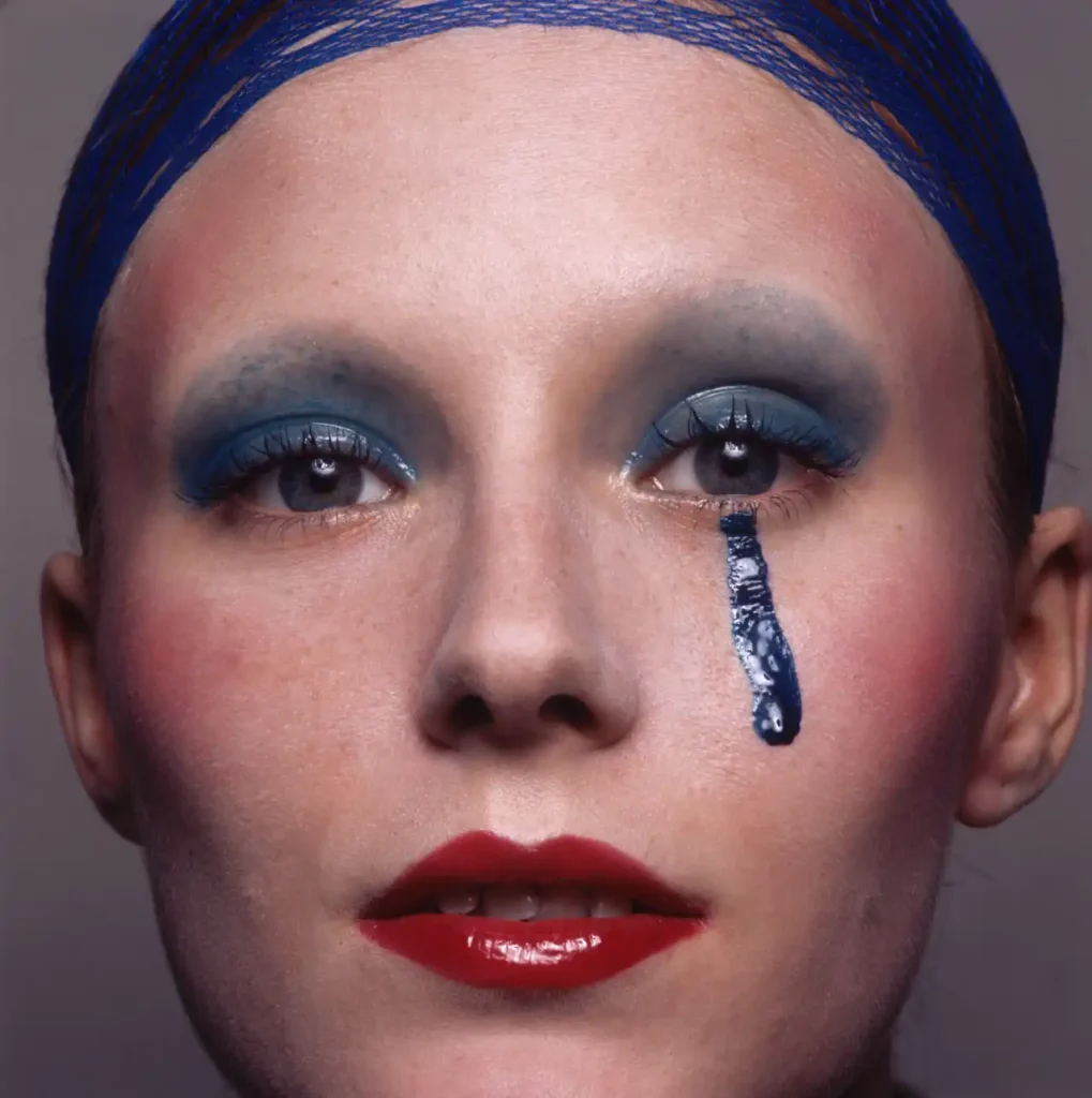 Portrait of model with blue teardrop by Guy Bourdin